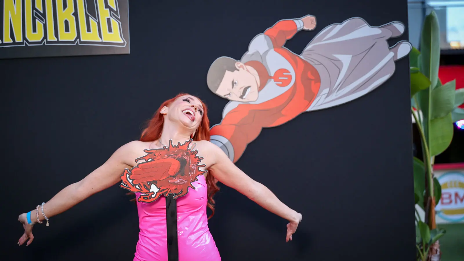 Creator @graciethecosplaylass poses with an in-house illustrated Thragg impact installation at Prime Video’s Invincible Season 4 creator event.