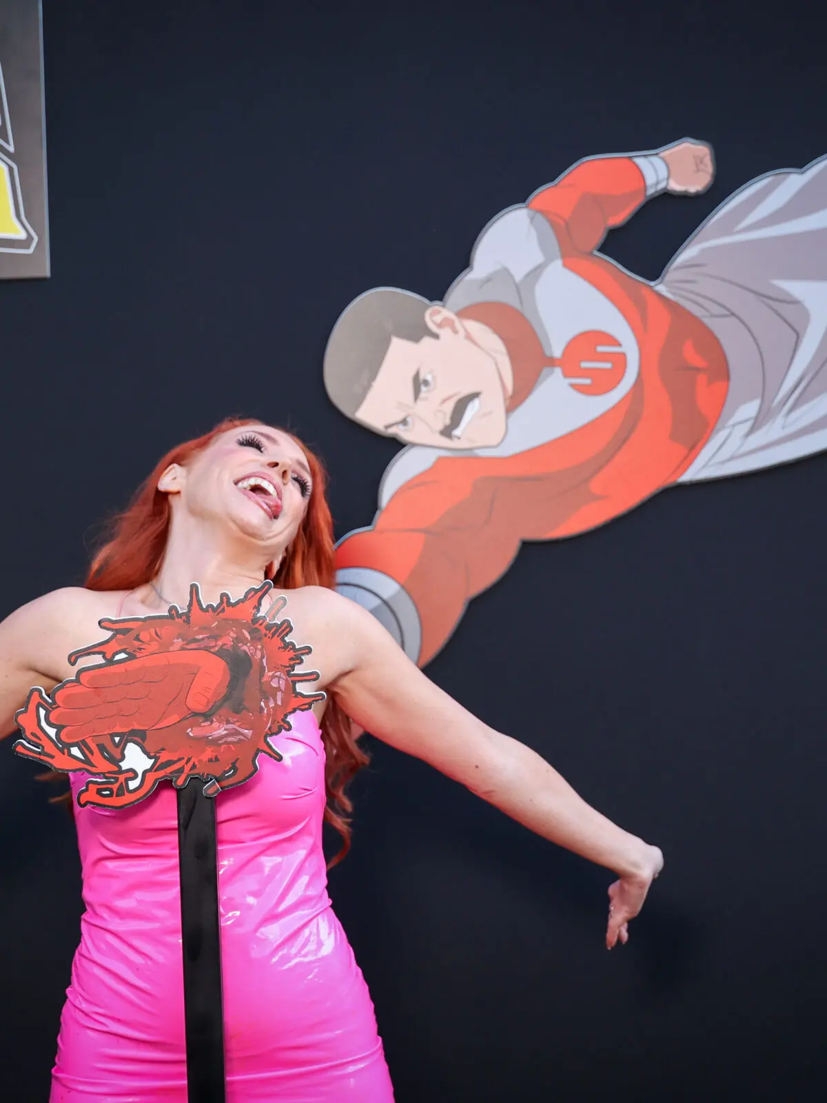 Creator @graciethecosplaylass poses with an in-house illustrated Thragg impact installation at Prime Video’s Invincible Season 4 creator event.