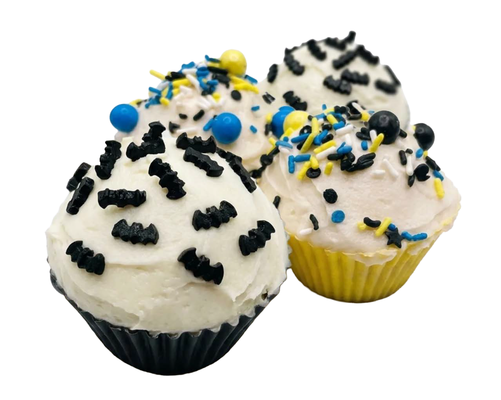 Three cupcakes with white buttercream, black bat-shaped sprinkles, and blue, yellow, and white round sprinkles in black and yellow paper liners.