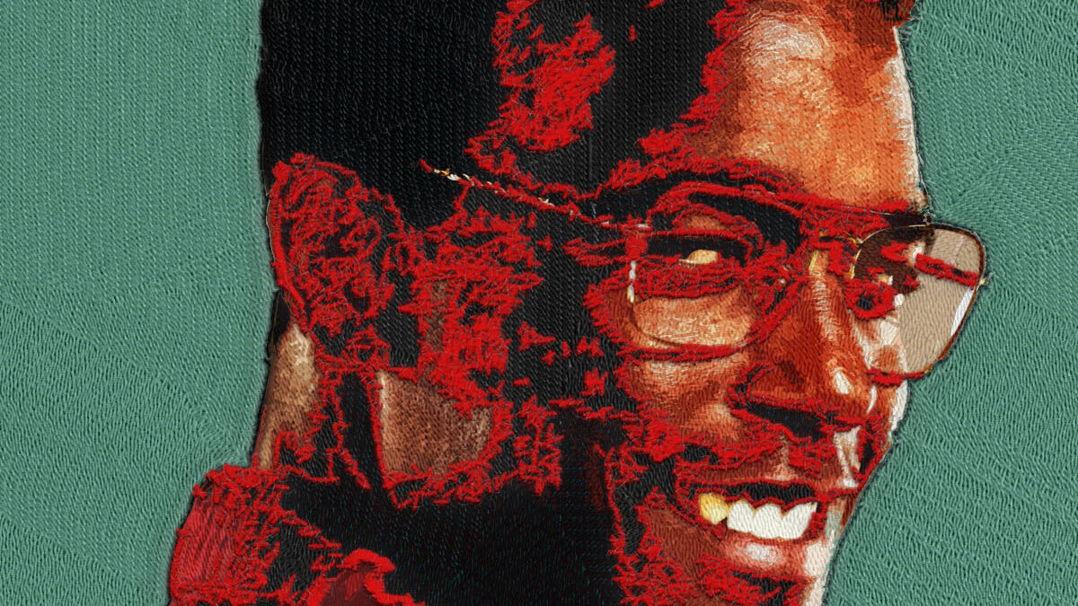 Yarn-textured portrait of Luke James for Prime Video’s THEM: The Scare, featuring a high-top fade, glasses, layered stitching, and a muted teal fabric background.