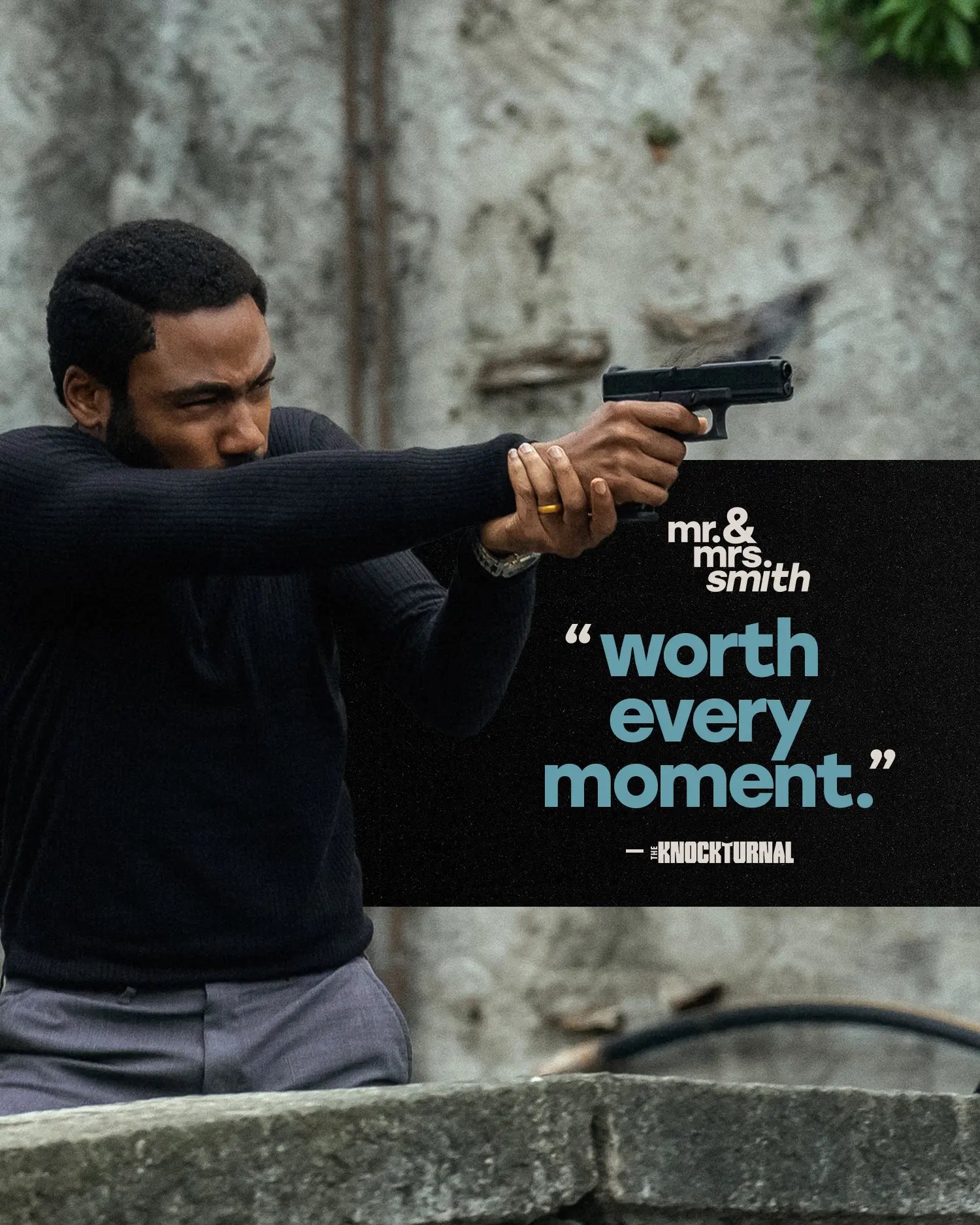 A Black man in a black sweater aims a pistol across a low stone barrier while a black rectangular quote panel overlays the right side reading “worth every moment.”
