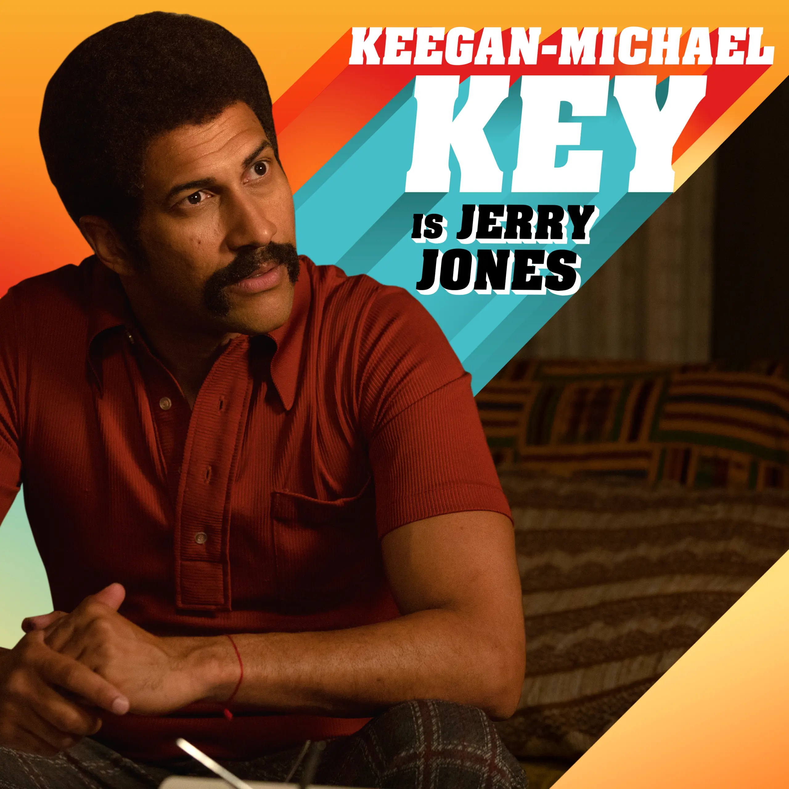 Keegan-Michael Key as Jerry Jones seated on a bed wearing a rust-red polo, with a thick mustache and 1970s-style graphic text and diagonal teal and orange stripes in the top-right.