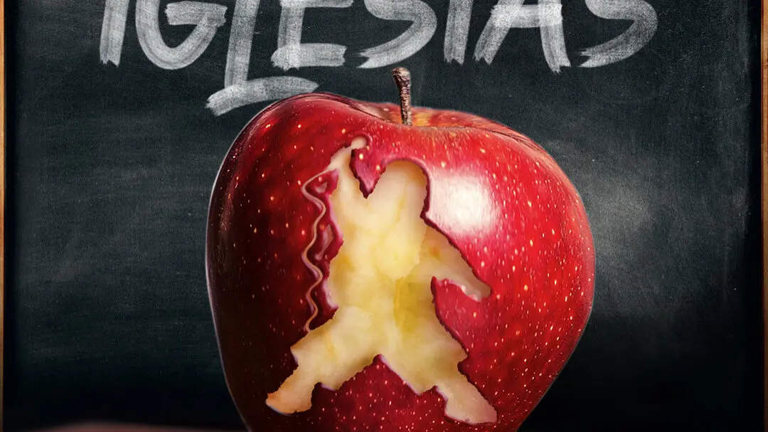 Mr. Iglesias promotional artwork featuring a red apple with Gabriel Iglesias’s silhouette carved into its side, placed on a textbook in front of a chalkboard.