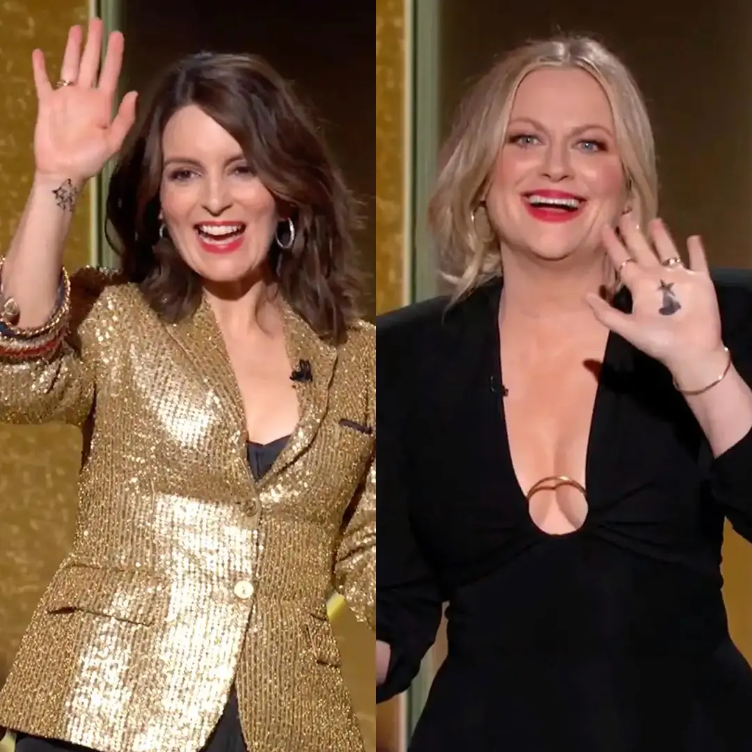 Golden Globes hosts Tina Fey and Amy Poehler wave while showing the heart-and-star markings on their hands.
