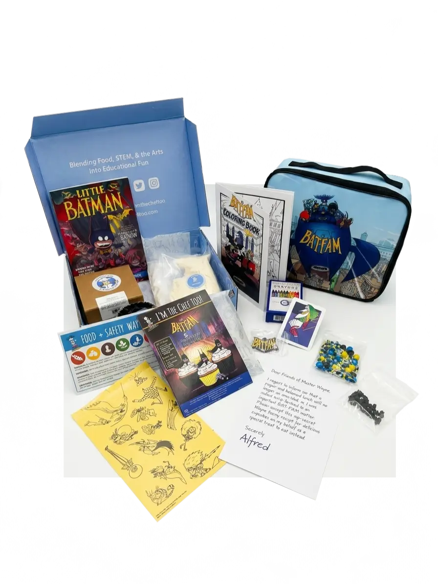 Open Bat-Fam influencer kit arranged on a white surface showing a branded blue box, BatFam lunchbox, coloring book, recipe booklet, sticker sheets, card pack, bagged sprinkles and chocolate, and an Alfred note.