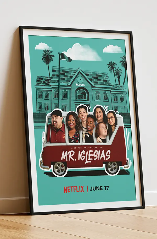 Framed teal poster leaning on a wooden floor showing a stylized school building with palm trees, characters riding a red school-bus sign labeled "Mr. Iglesias," and a Netflix June 17 release line.