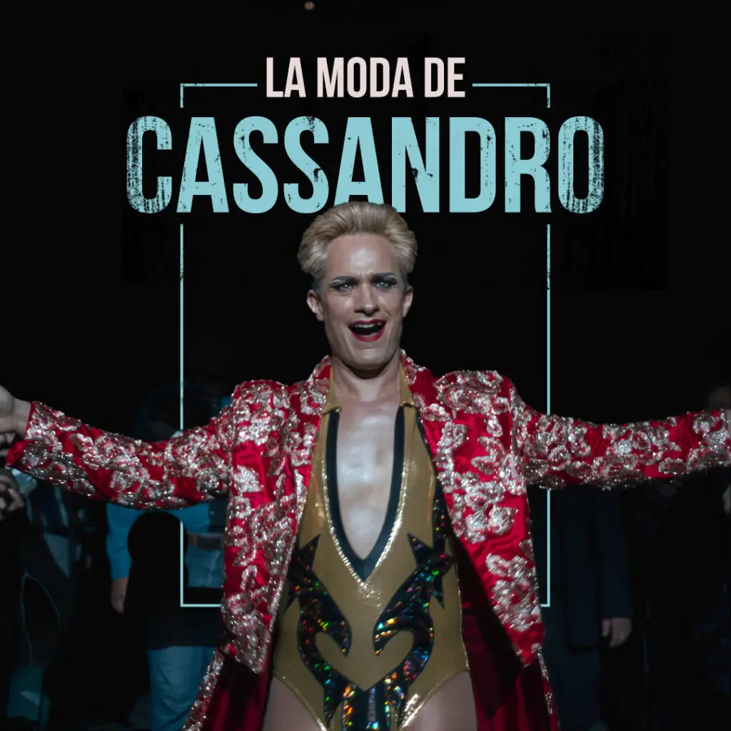 Cassandro stands with arms outstretched in a red embroidered wrestling jacket beneath the Spanish headline “La Moda de Cassandro.”